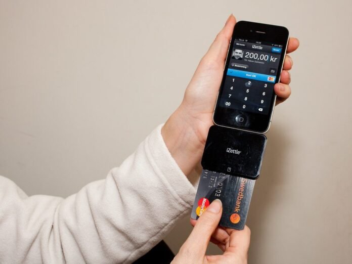 Customer paying by card on a mobile payment terminal attached to a smartphone