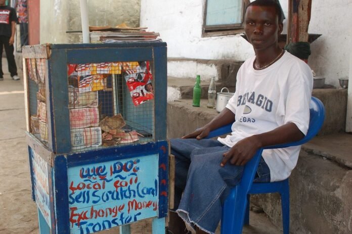 Mobile phone scratch card vendor at a street kiosk in Kenya