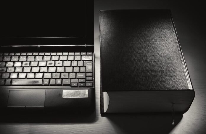 Laptop beside a book, representing online learning and certificates