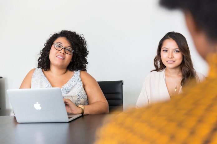 Tech professionals working on a laptop in an office meeting