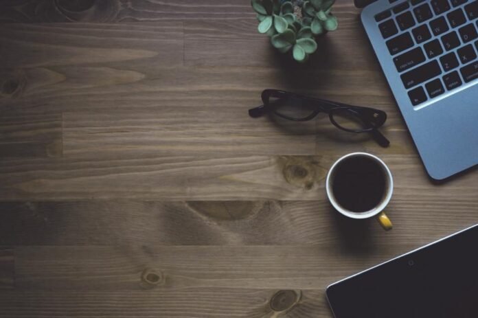 Laptop, glasses and coffee on a wooden desk