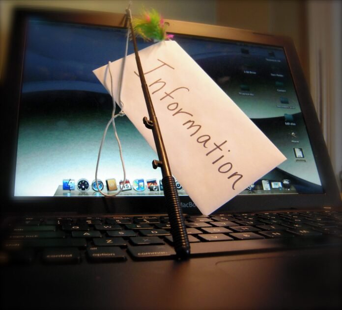 Laptop with a hook holding an information card, illustrating phishing
