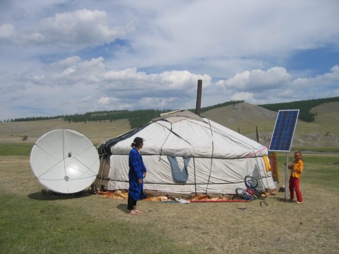 Satellite dish and solar panel beside a rural home