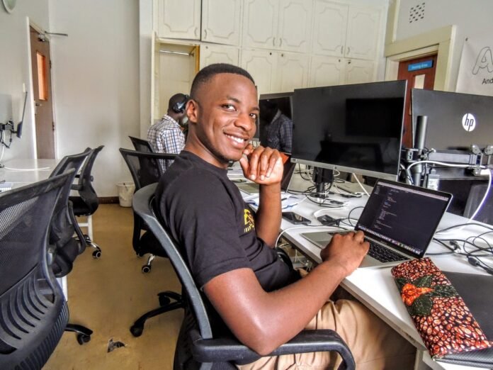 Software developer at work at a computer desk in Uganda