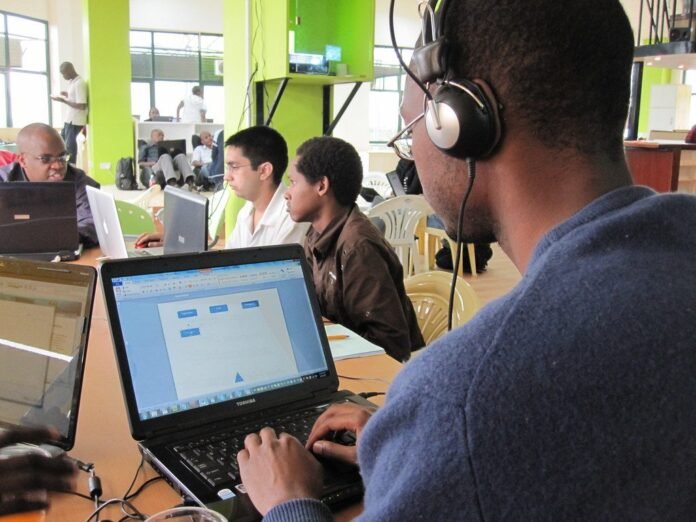 Young developers coding on laptops at a hackathon in Nairobi, Kenya