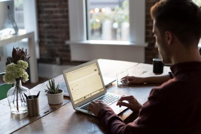 Person typing on a laptop at a work desk